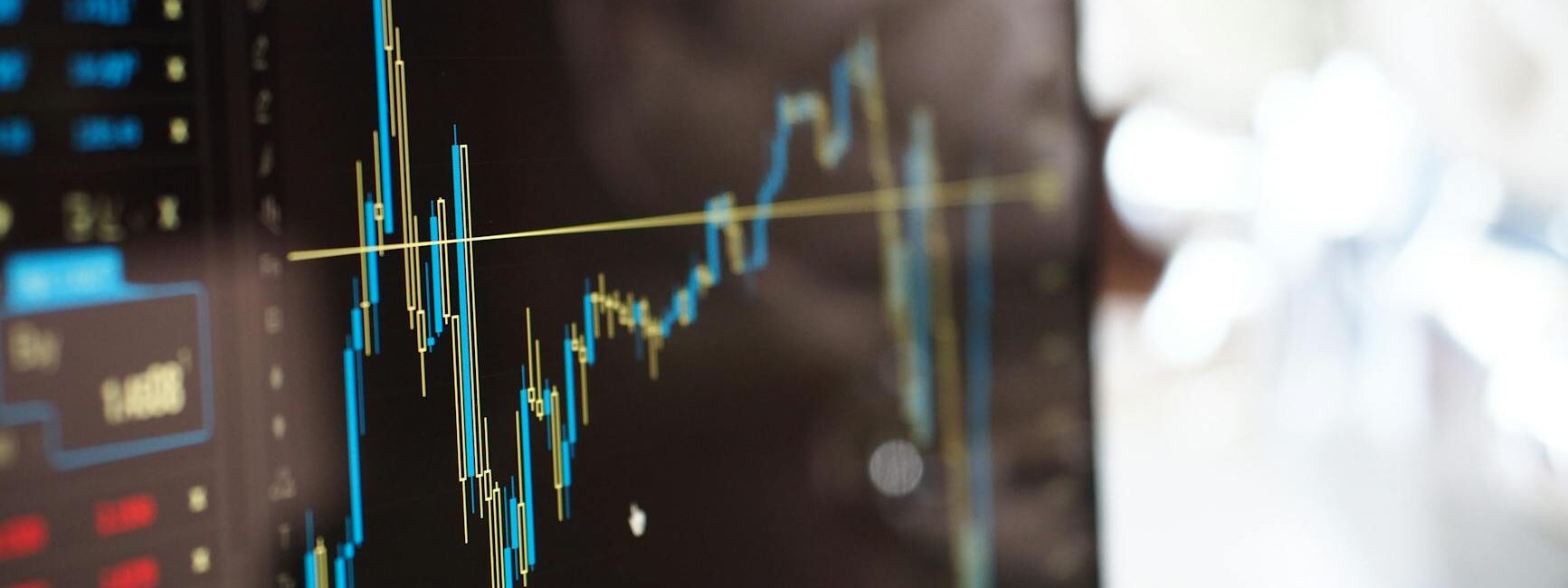 Detailed view of financial trading graphs on a monitor, illustrating stock market trends.